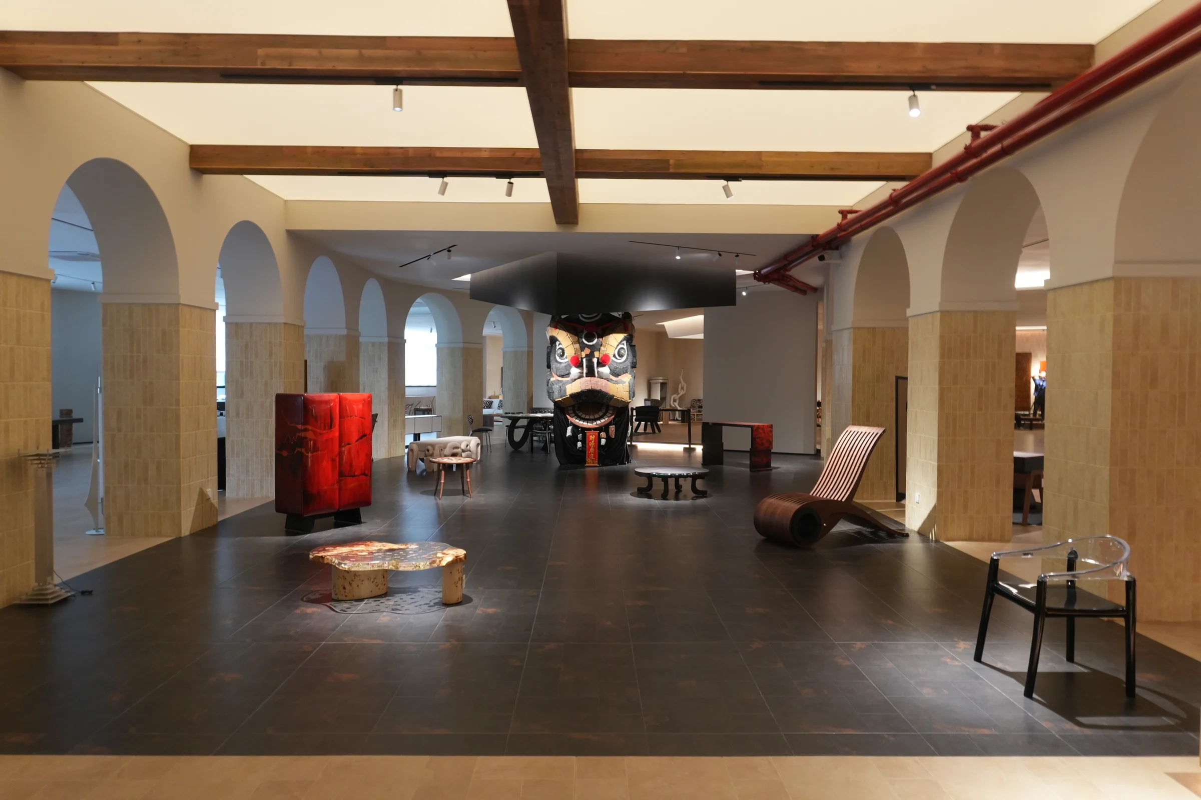 Arched Cantonform showroom with a red cabinet, stone coffee tables and curved wooden seating